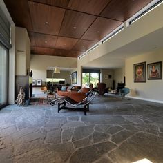 a living room with stone flooring and wooden ceiling