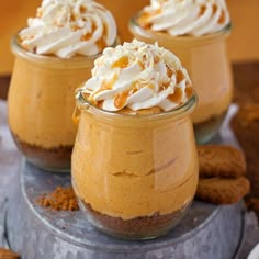 three desserts with whipped cream and cookies in them