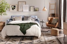 a bed sitting on top of a wooden floor next to a chair and table in a bedroom