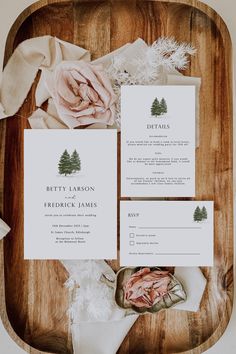 the wedding stationery is laid out on a wooden tray with flowers and napkins