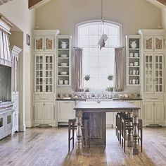 a large kitchen with an island in the middle and lots of cabinets on both sides