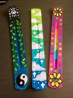 three different colored toothbrushes with designs on them sitting on a table next to each other