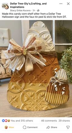 a gold and white bag with a bow on it's side, sitting on top of a table