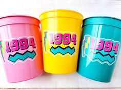 three colorful plastic cups with the words pee pee on them are sitting next to each other