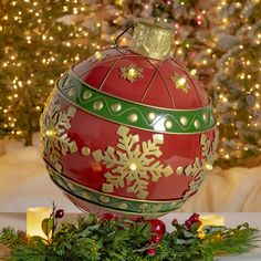 a christmas ornament sitting on top of a table next to a lit tree