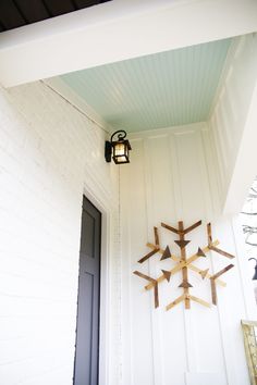 a snowflake hanging on the side of a white wall next to a door