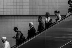 many people are walking up an escalator