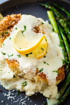 a plate topped with chicken, mashed potatoes and asparagus