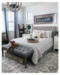 a dog sitting on top of a bed in a room with white walls and furniture