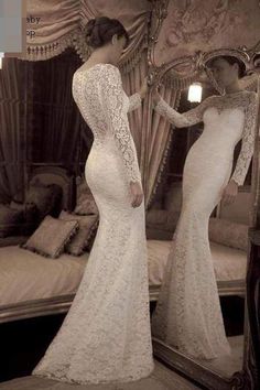 two women in white dresses are looking at each other's reflection in a mirror