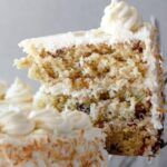 a piece of cake with white frosting and crumbs on it is being held by a fork