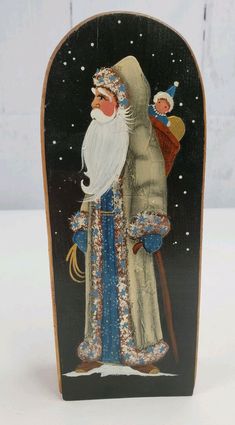 an image of santa claus holding a doll