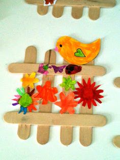 paper flowers and birds are placed on popsicle sticks to make a bird craft for kids