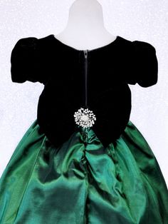 Beautiful handmade dress that's perfect for the holidays, birthday parties, pageants, photoshoots, and any formal event! The short sleeved bodice is made out of black velvet. A taffeta belt with rhinestone application is attached to the bodice The zipper can be found on the back. Comes with a detachable velvet bow with rhinestone broach accent. The skirt is made out of taffeta material With a layer of lining with crinoline attached underneath everything to give the dress shape. *Mannequin has pe Elegant Green Pageant Dress For Dress-up, Elegant Fitted Green Princess Dress, Elegant Princess Dress For Holiday Dress-up, Fitted Satin Princess Dress For Pageants, Princess Style Fitted Pageant Dress For Formal Events, Fitted Satin Ball Gown For Pageants, Fitted Satin Princess Pageant Dress, Satin Fitted Ball Gown For Pageants, Fitted Satin Ball Gown Pageant Dress