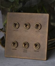 the four buttons are on the metal plate with flowers in it's centerpiece