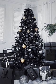 a black and white christmas tree in a living room with presents on the floor next to it