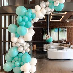 the balloon arch is decorated with blue, white and silver balloons for an elegant party