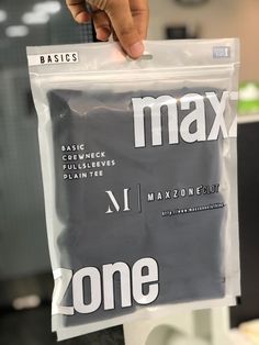 a person holding up a plastic bag with the word max on it