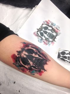 a person with a skull tattoo on their arm