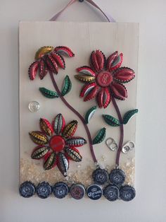 a wall hanging with buttons and flowers on it's side, attached to the wall