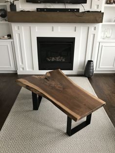 a wooden table sitting in front of a fireplace with a tv on top of it