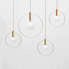 three circular lights hanging from the ceiling with gold wires and two white balls on them