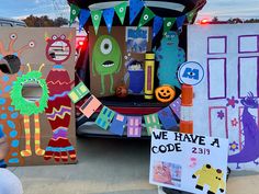 the back end of a car decorated with paper cut out monsters and other decorations for halloween