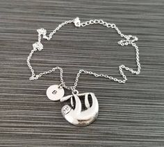 "Gorgeous Detailed Antique Silver Sloth Charm Necklace! A detailed smiling sloth charm on a bright silver chain makes the perfect gift for you or your best friend. The sloth charm is made from zinc alloy and measures 26 mm by 24 mm. The chain is silver plated and measures 16\" or 18\" with a 1\" extender. You can also personalize your necklace with a .5\" silver plated disc stamped with the initial of your choice. To order your necklace WITHOUT a custom stamped initial disc, choose \"Charm & Silver Novelty Necklaces With Charms, Novelty Silver Necklaces With Charms, Novelty Silver Charm Necklace For Gift, Silver Novelty Charm Necklace For Gift, Silver Novelty Necklace For Gift, Silver Necklaces With Charms, Smiling Sloth, Sloth Necklace, Sloth Gift