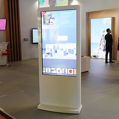 people are standing in an exhibit looking at the screen