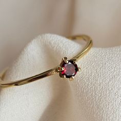 Delicate and simple, this ring is made with a genuine AAA Garnet gemstone set in a 925 silver ring, finished with a thin layer of gold.  Light weight and great quality, this ring is perfect for everyday use and would make the perfect gift for a loved one. The ring will  come nicely packed , ready to be gifted or just to keep to yourself.  With proper care, gold plated jewelry may last for years. Here are some tips to care of your gold plated ring:  Remove your jewelry before you swim in chlorine or salt water. Remove your jewelry before participating in activities that will cause you to sweat a lot. Wait to put on your jewelry until after you have applied lotion, makeup or perfume. Remove jewelry if you will be bringing it into contact with something hard. (For example, take off your ring Garnet Ring Gold, Stackable Birthstone Rings, Garnet Ring Silver, Birthstone Rings, Silver Diamond Ring, Dark Autumn, Tiny Rings, Ring Birthstone, Garnet Ring