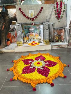 a large flower arrangement on the ground in front of a shrine with flowers all over it