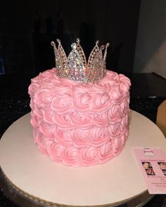 there is a pink cake with a crown on top