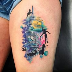 a woman's thigh with a clock tower tattoo on her left leg and people flying around the clock