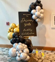 a welcome sign surrounded by balloons on a table