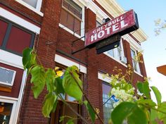 a red brick building with a sign that says freebull hotel hanging from it's side