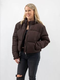 On a cold winter day, there's nothing better than snuggling up in a cozy jacket. But just because you're bundled up doesn't mean you have to sacrifice style. This dark brown cropped puffer jacket perfectly combines comfort and fashion. The quilted construction and standing collar will keep you warm, and because it's slightly cropped, it's the perfect piece to pair with leggings or jeans. So don't let the cold weather keep you from looking your best. Add this jacket to your outerwear collection a Brown Winter Puffer Jacket For Cold Weather, Brown Winter Puffer Outerwear, Brown Puffer Outerwear For Winter, Brown Puffer Jacket For Winter Streetwear, Brown Puffer Jacket With Padded Collar For Streetwear, Brown Puffer Outerwear For Cold Weather, Brown Quilted Winter Outerwear, Casual Brown Quilted Jacket For Winter, Casual Brown Quilted Winter Jacket