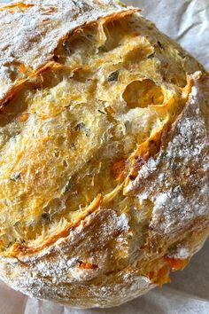 a round bread sitting on top of a piece of wax paper covered in powdered sugar