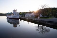 a boat is docked in the water near some houses and trees on the other side