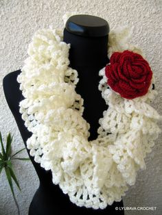 a crocheted scarf with a red rose on it