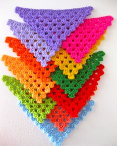 there are many crocheted squares that have been made into a wall hanging on the wall