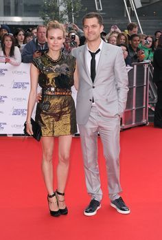 a man and woman standing on a red carpet next to each other in front of a crowd