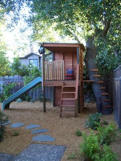 a backyard with a tree house and slide