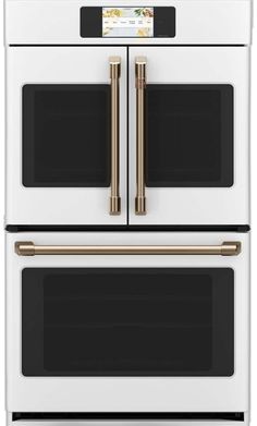 two white ovens with gold handles on each side and one is built into the wall