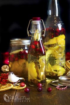 two jars filled with fruit sitting on top of a wooden table next to other items