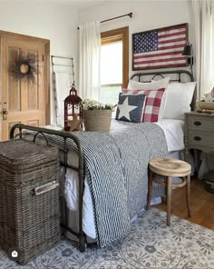 a bedroom with an american flag quilt on the bed and two wicker baskets in front of it