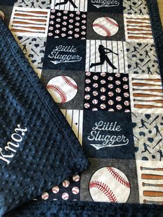 a quilted baseball themed blanket with the name little sluggers on it and an embroidered baseball