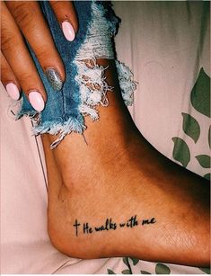 a woman's foot with the words, he walks with me tattooed on it