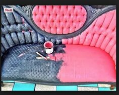 a pink and black couch with some paint on it