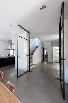 an open floor plan with white walls and black glass partitions in the center area