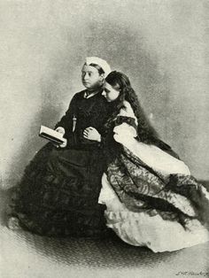 an old black and white photo of a man and woman sitting together, one holding a book